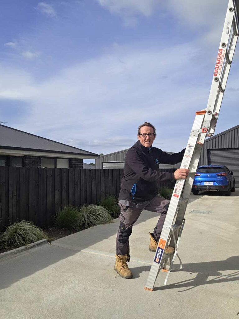 Hobart Building Inspections – licensed builder Chris Westcott on ladder during inspection